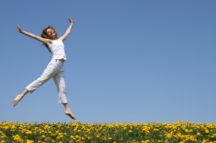 Pretty girl dancing in flowering meadow